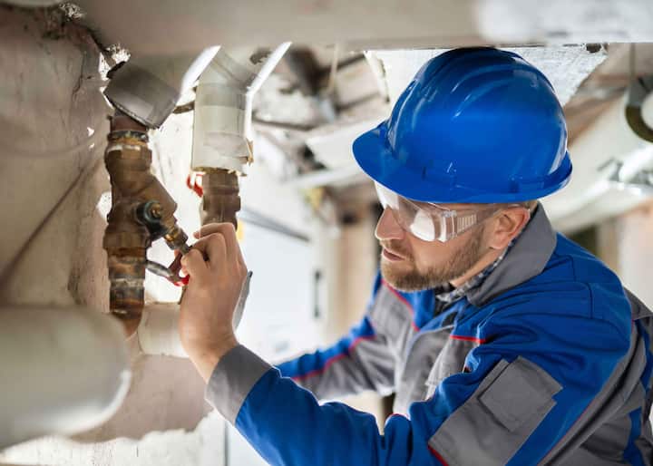 A water damage professionals inspecting pipes on commercial property in Allentown, PA.